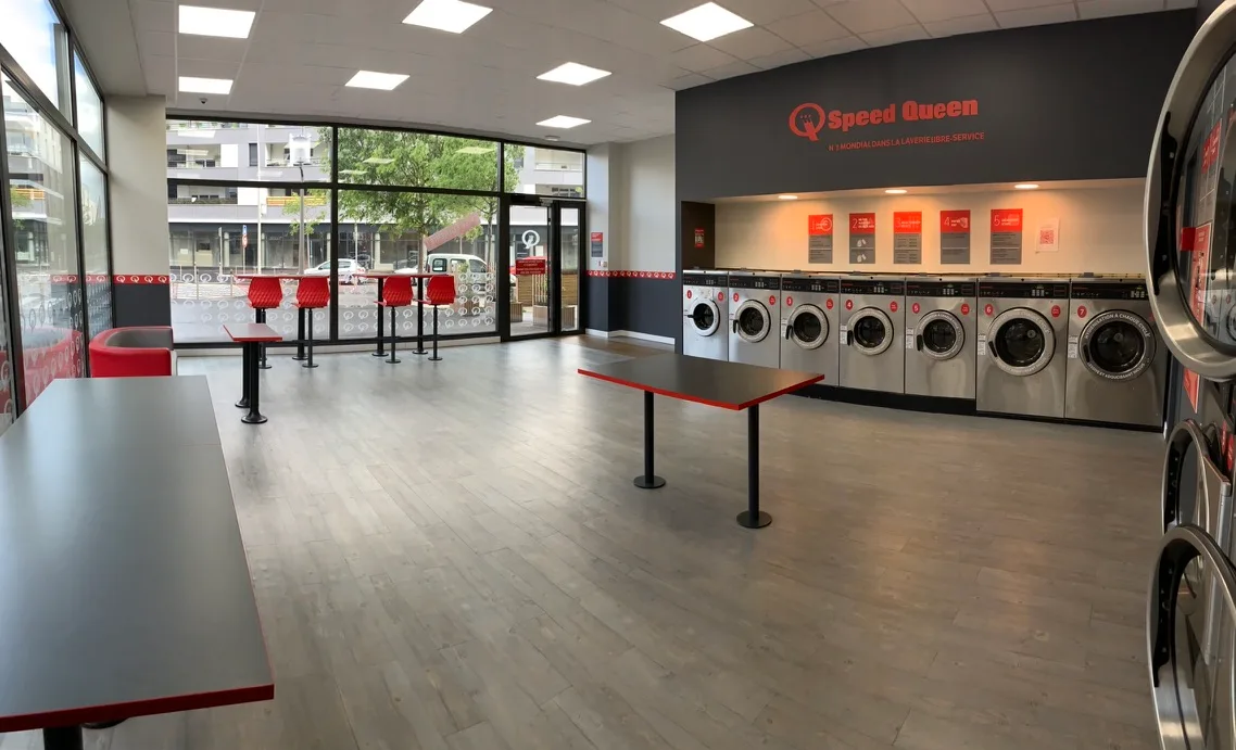 Intérieur lumineux avec baie vitrée, laverie Speed Queen Blagnac Andromède